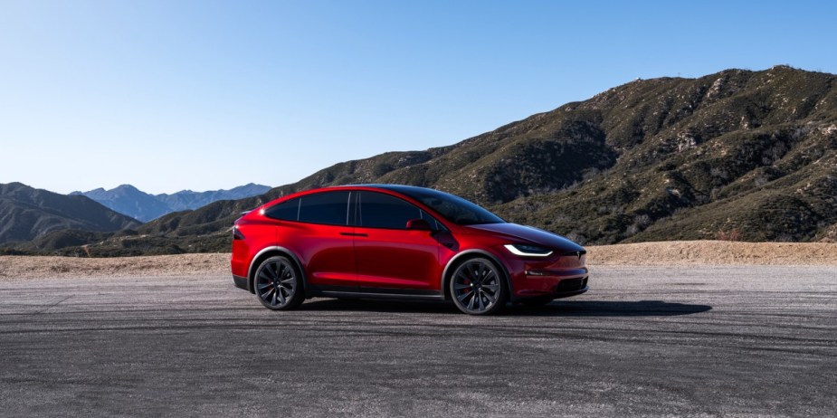 A red 2023 Tesla Model X is parked. 