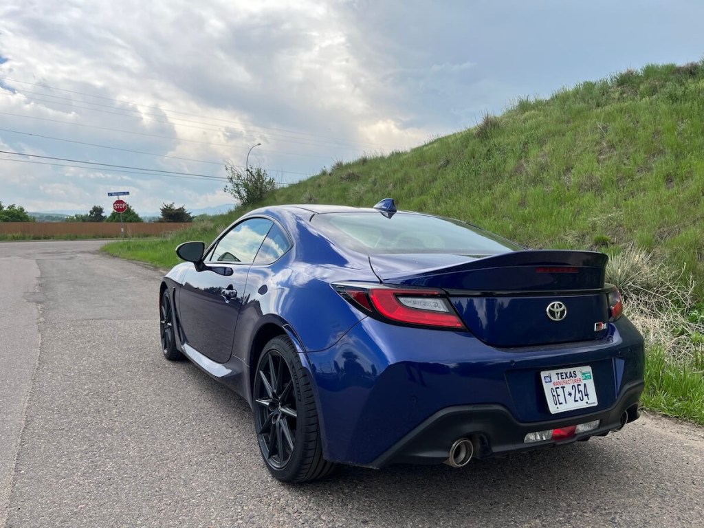 A rear view of the 2023 Toyota GR86 near a hill