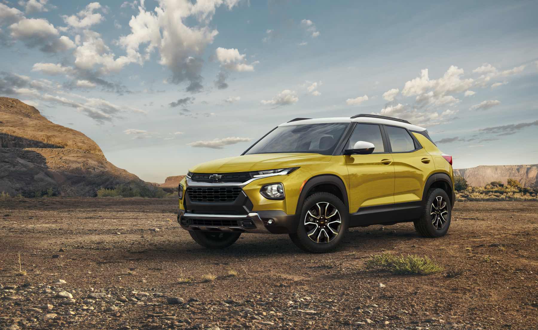 A yellow 2023 Chevy Trailblazer sits in a desert landscape. It's one of Chevy's cheapest SUVs.