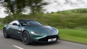 A green 2023 Aston Martin Vantage on a green hillside road