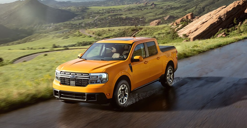 A yellow 2023 Ford Maverick is driving down the road as a small truck.