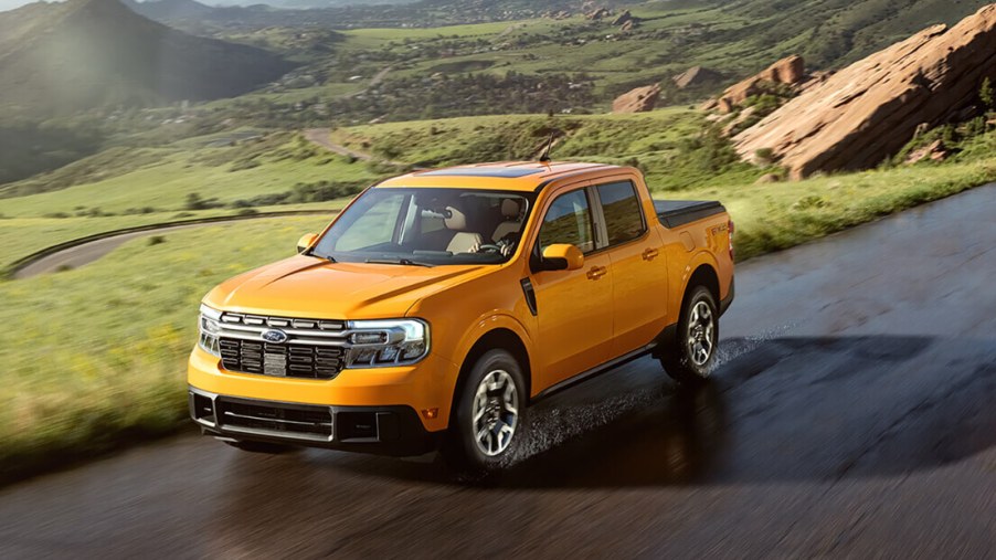 A yellow 2023 Ford Maverick is driving down the road