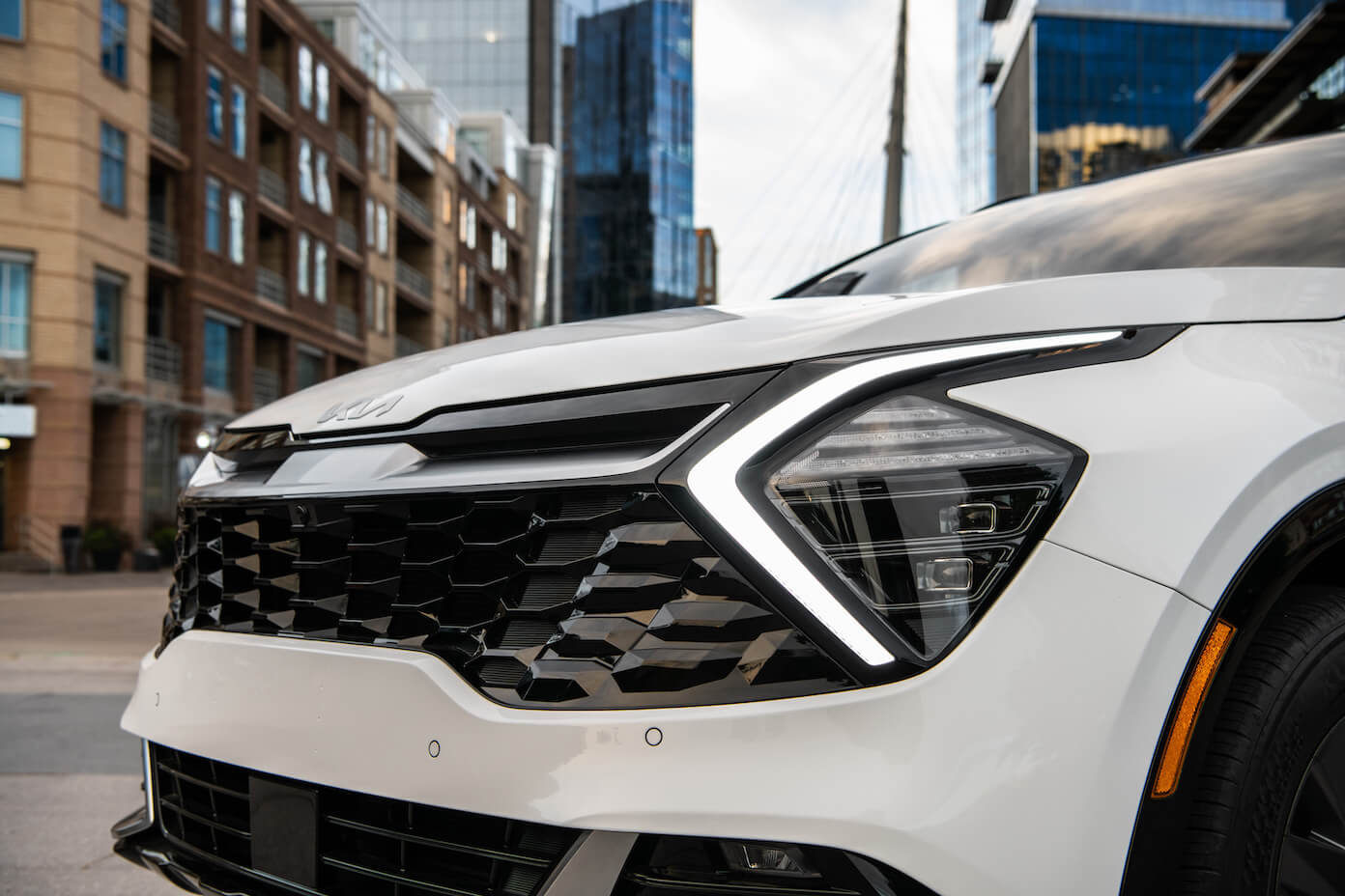 The front grille of a white 2023 Kia Sportage