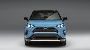 A blue 2023 Toyota RAV4 XSE against a silver/gray background.