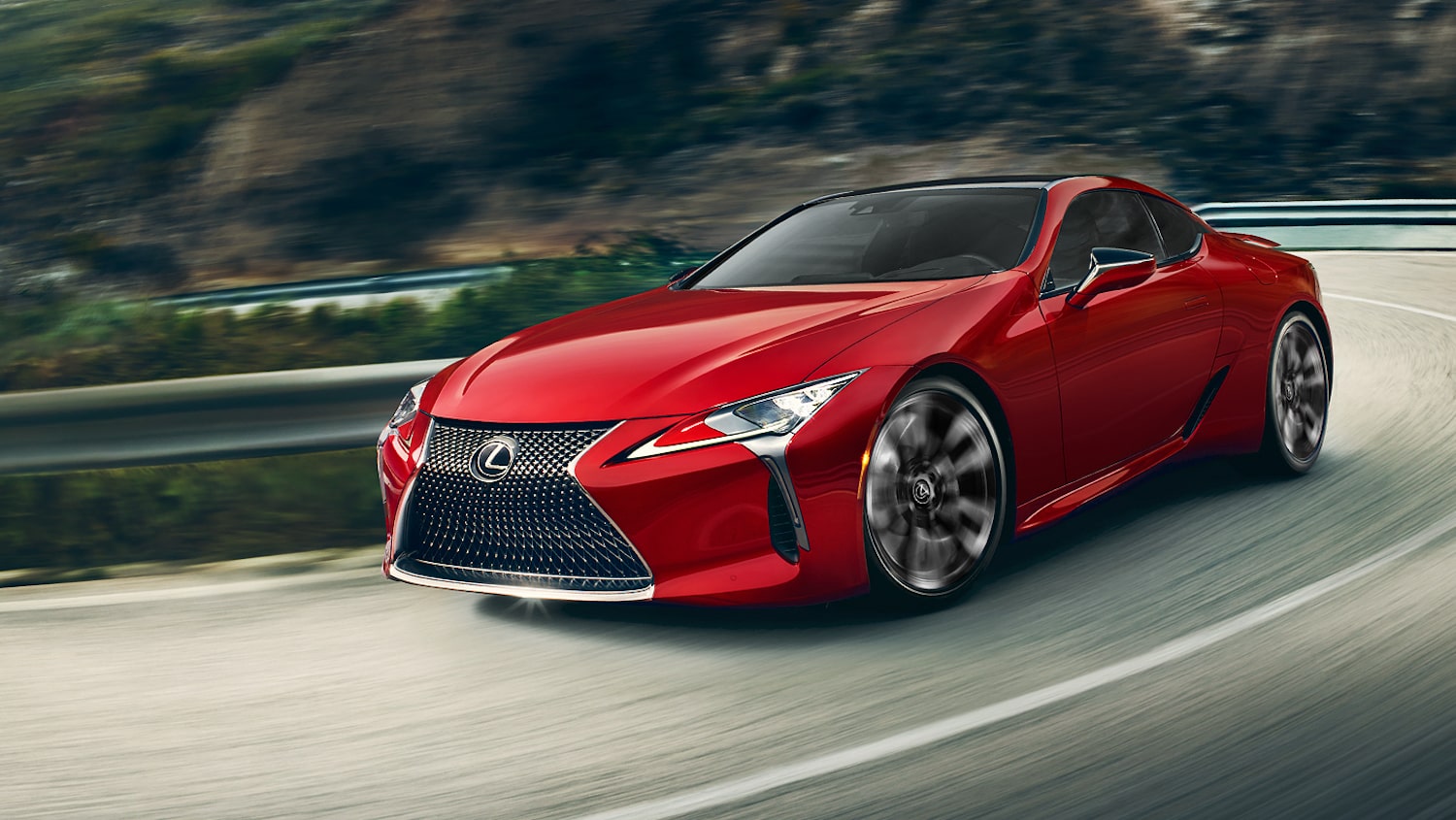 A red 2024 Lexus LC driving around a bend