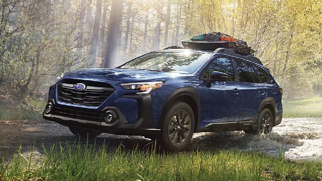 2024 Subaru Outback crossover SUV driving through a forest