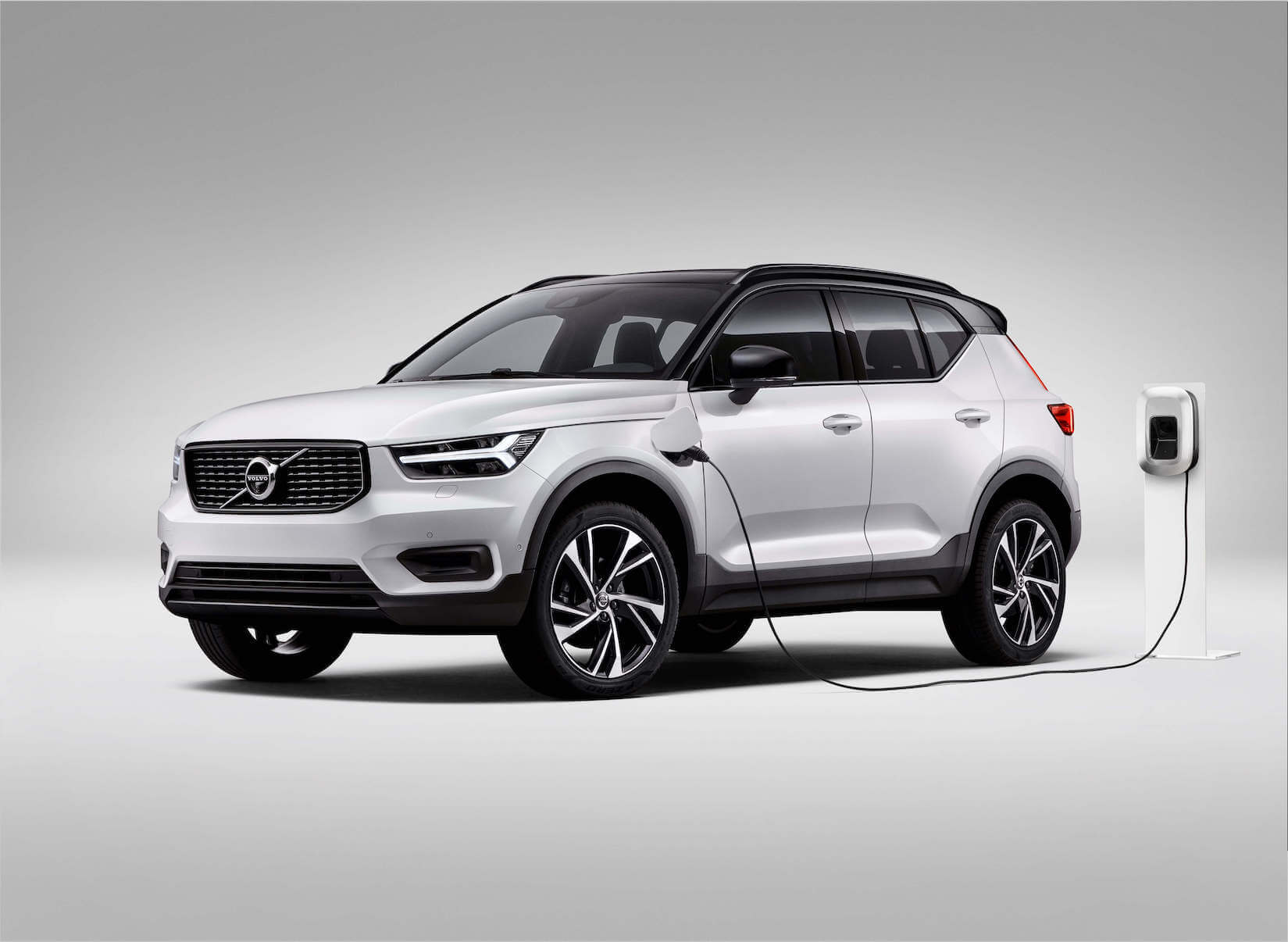 A silver 2023 Volvo XC40 Recharge Plug-in Hybrid plugged in to charge.