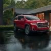 A red GMC Acadia in the rain. The GMC Acadia has three common problems that owners report. Is it reliable?