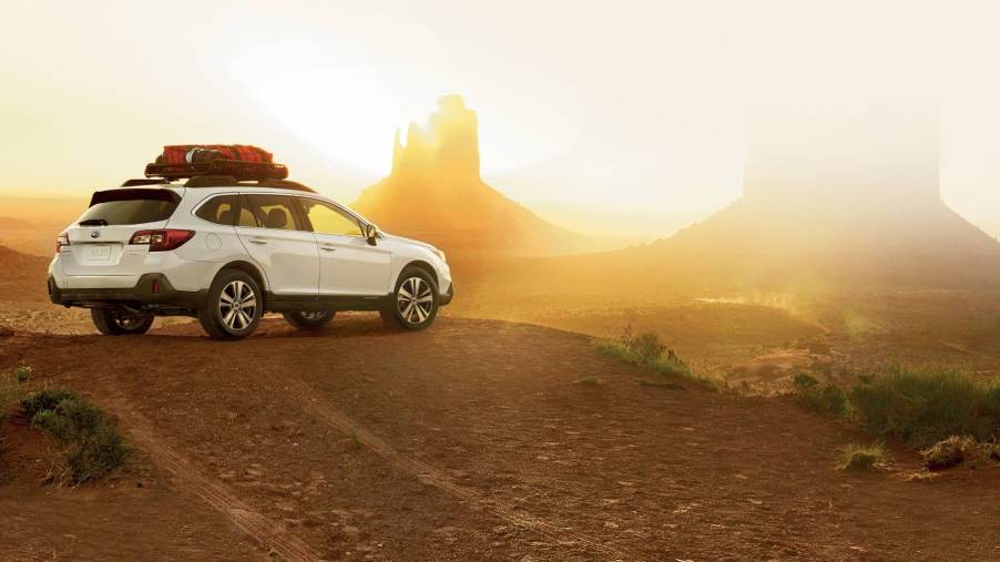 A white 2019 Subaru Outback looks out over Monument Valley at dusk. The Subaru Outback has plenty of strengths and weaknesses.