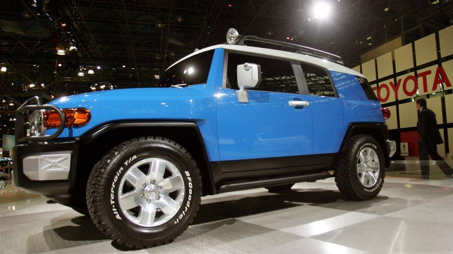 A blue Toyota FJ Cruiser sits on display at an auto show.