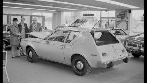 An unidentified couple (at left) speaks with an automobile salesman about an American Motors Corporation (AMC) Gremlin in showroom