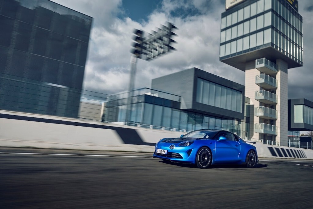 A blue Alpine A110 R driving on track