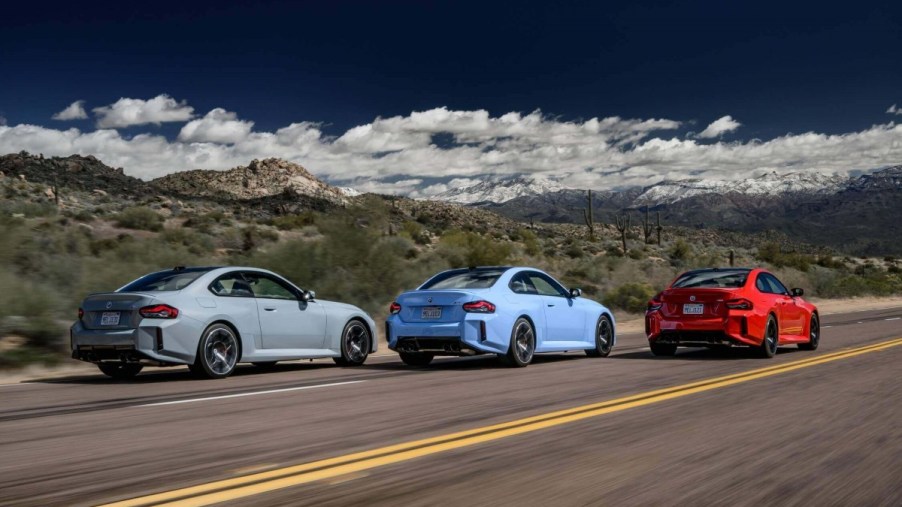Three BMW M2 models on a highway without a turn signal in sight.