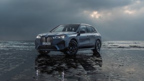 A blue 2024 BMW iX midsize luxury electric SUV is parked.