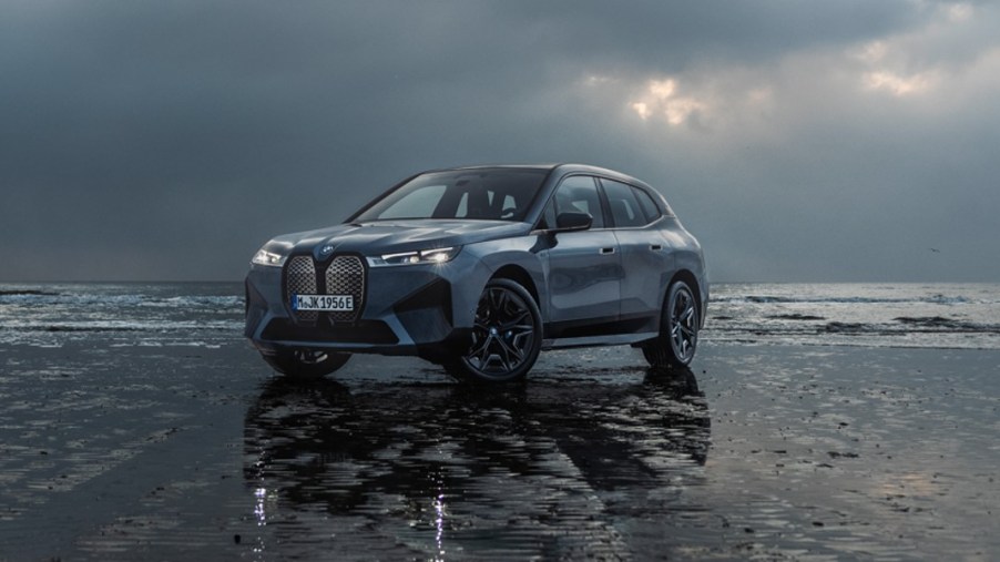 A blue 2024 BMW iX midsize luxury electric SUV is parked.