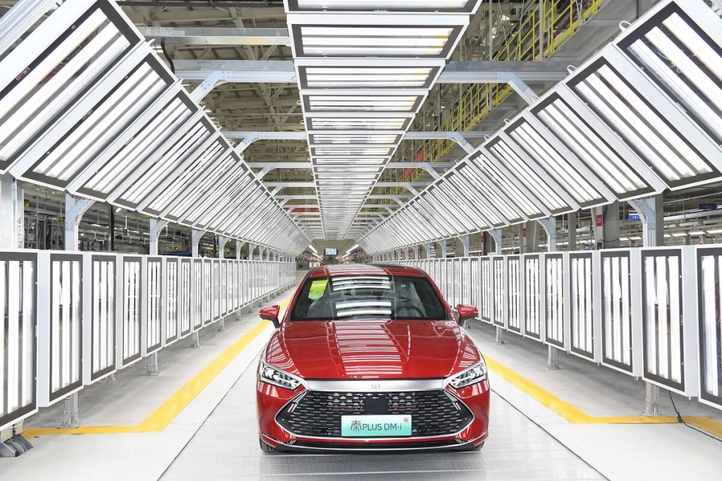 A red EV from the Chinese car brand BYD heads to export from the factory. 