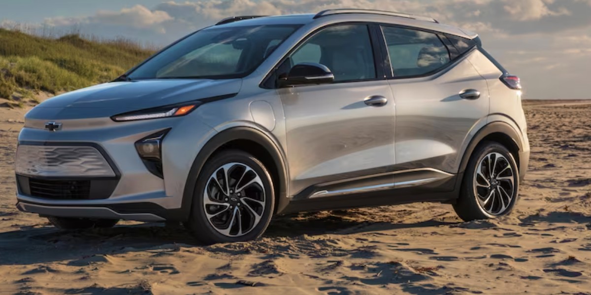 A gray 2023 Chevrolet Bolt EUV subcompact electric SUV is parked on the sand.