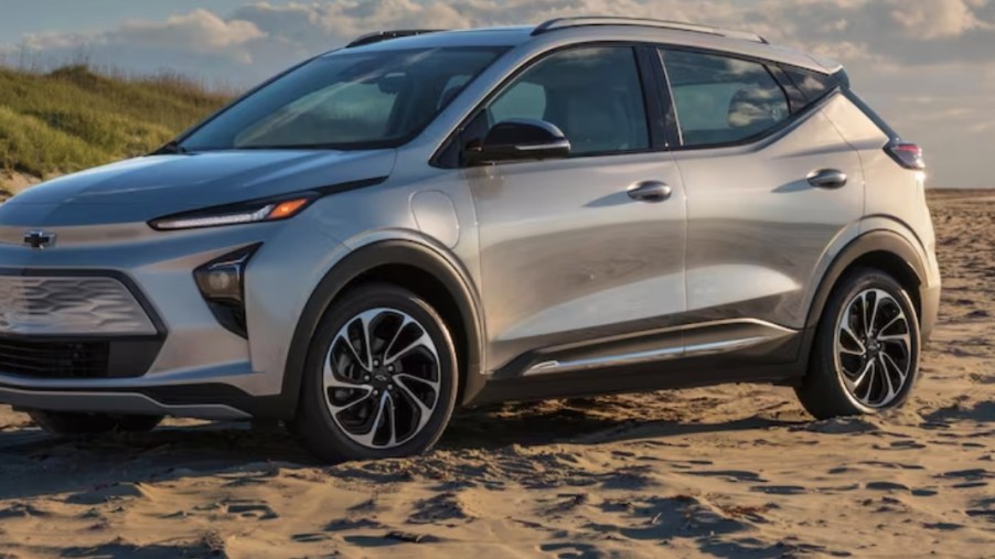 A gray 2023 Chevrolet Bolt EUV subcompact electric SUV is parked on the sand.