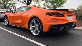 A bright orange hybrid electric Chevrolet Corvette E-Ray C8 shows off its rear-end styling.