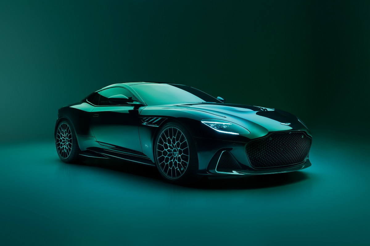 A green Aston Martin DBS 770 Ultimate in green parked in a photo studio