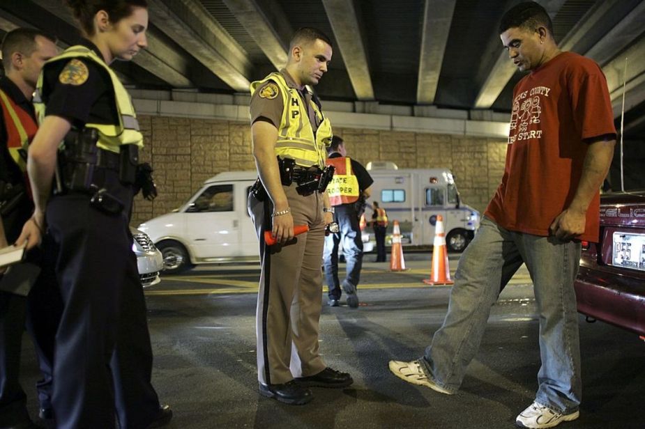 Police offers give a field sobriety test at a DUI checkpoint.
