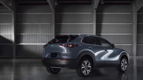 A light blue Mazda CX-30 sits in a hanger with its rear to the camera. The CX-30 is a crossover that's still great for driving.