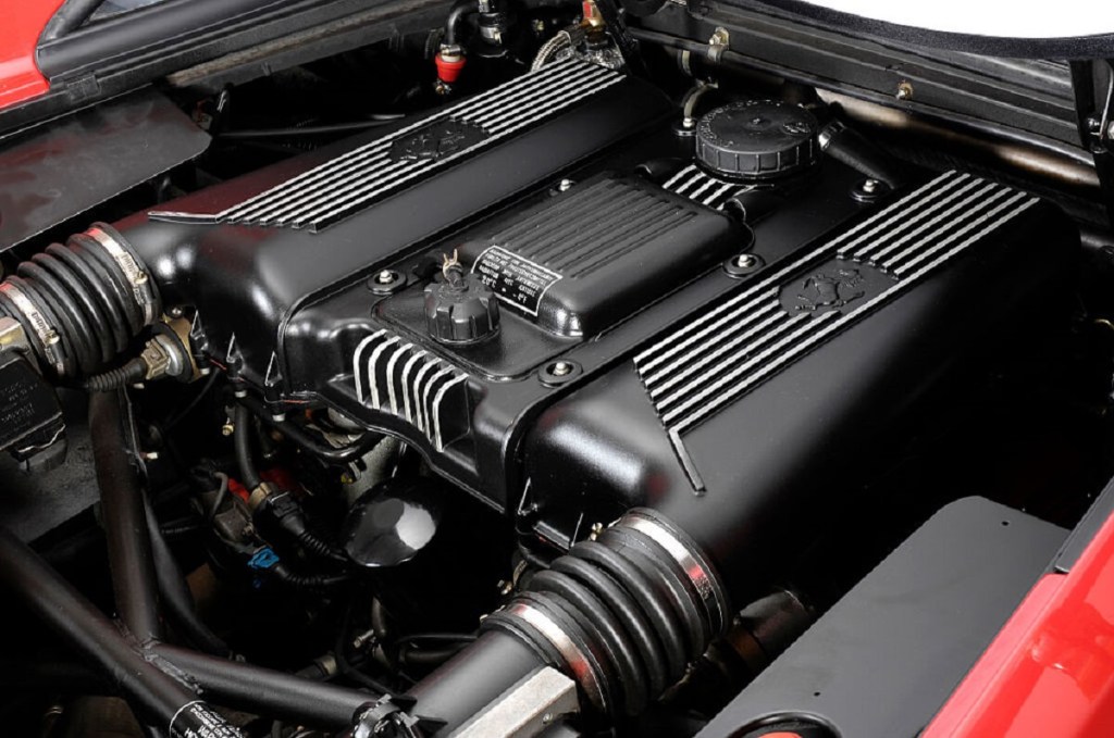 A used Ferrari F355 shows off its new valve covers on its engine. 