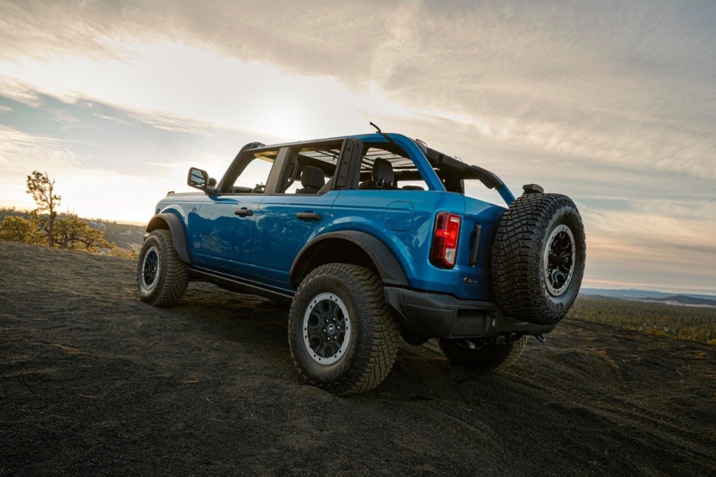 A blue Ford Bronco ascends an off-road hill. The Ford Bronco offers three engines to consider.