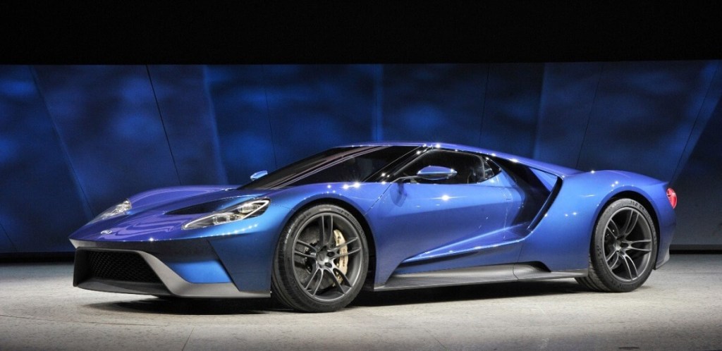 A blue Ford GT halo car sits on a stage at a car show. 