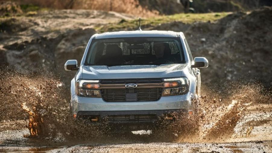 The Ford Maverick Tremor pickup truck is driving through mud.