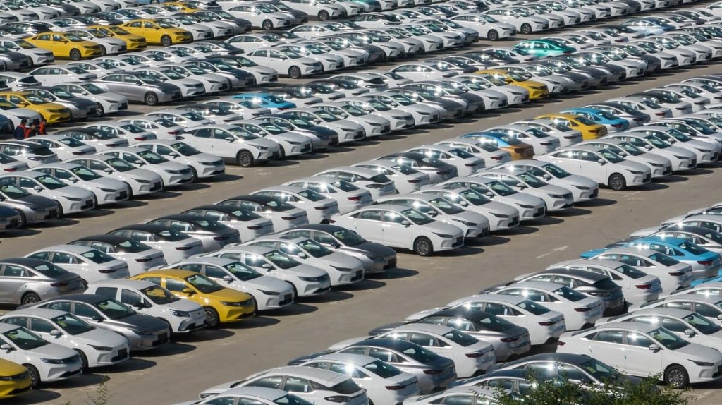 Many Chinese cars await pickup at a Geely lot.