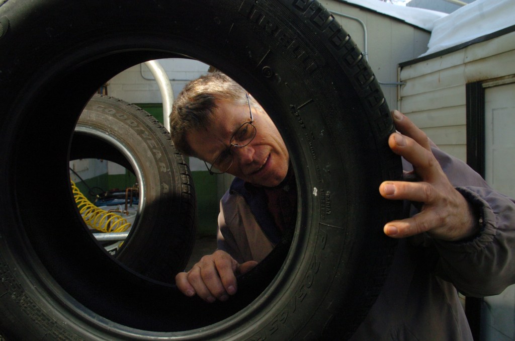 A man inspects a car tire