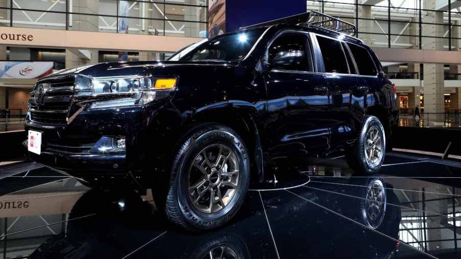Long known as one of the best three-row off-road SUVs, the Toyota Land Cruiser sits on display at an auto show.