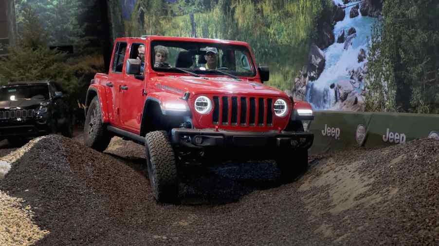A red 2018 Jeep Wrangler shows its off-road performance at a press demonstration. The 2018 model was one of the best years for the Jeep Wrangler.