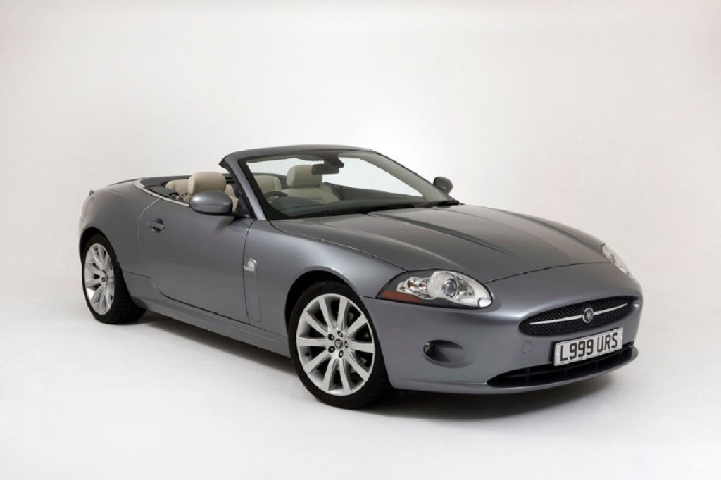 A used Jaguar XK, like the XKR, shows off its convertible top and luxury GT car lines.