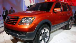 An orange Kia Borrego on display at an auto show.