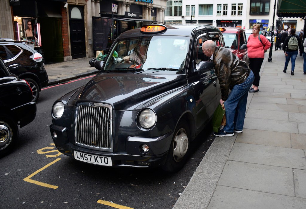 A London Black Taxi picking up a passenger