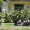 Man Mowing Lawn with a Push Mower - With proper lawn mower service, this mower can last all season long
