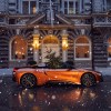 An orange BMW i8 Roadster with a Christmas tree in the passenger seat