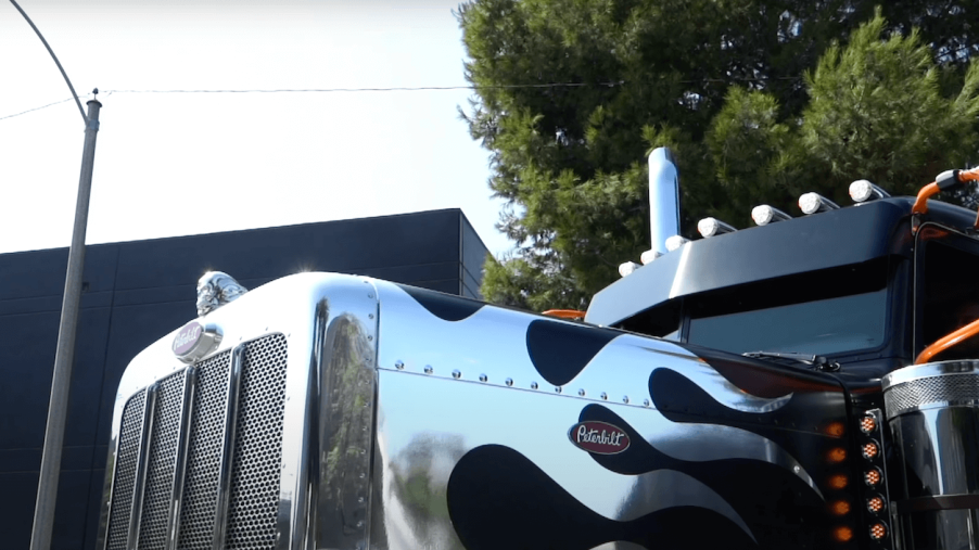The chrome hood decals and hood ornament of on a custom Peterbilt truck.