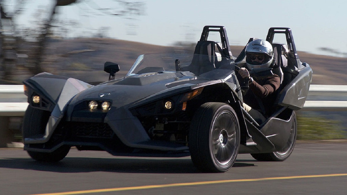 A gray Polaris Slingshot three-wheeler hits the road. 