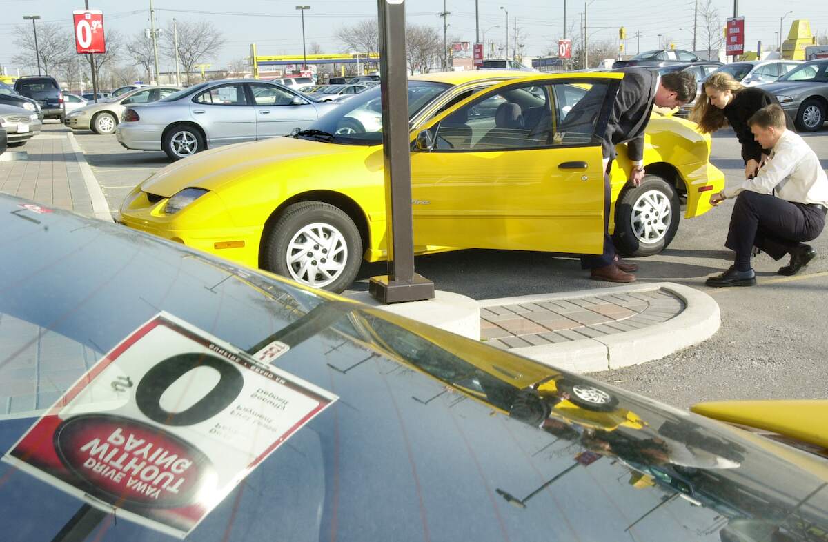 GMC General Sales Manager David Lyon shows prospective buyers a new Pontiac Sunfire in December 2001