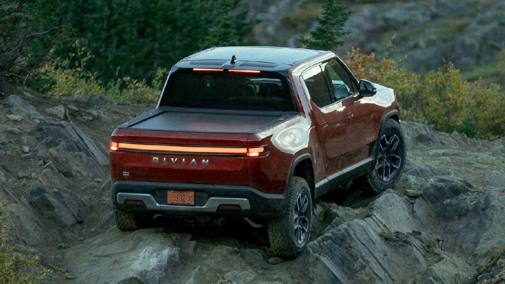 Rear view of orange 2023 Rivian R1T electric truck, showing that off-road driving is bad for the environment