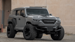 Gray Rezvani Tank Military with warehouse backdrop