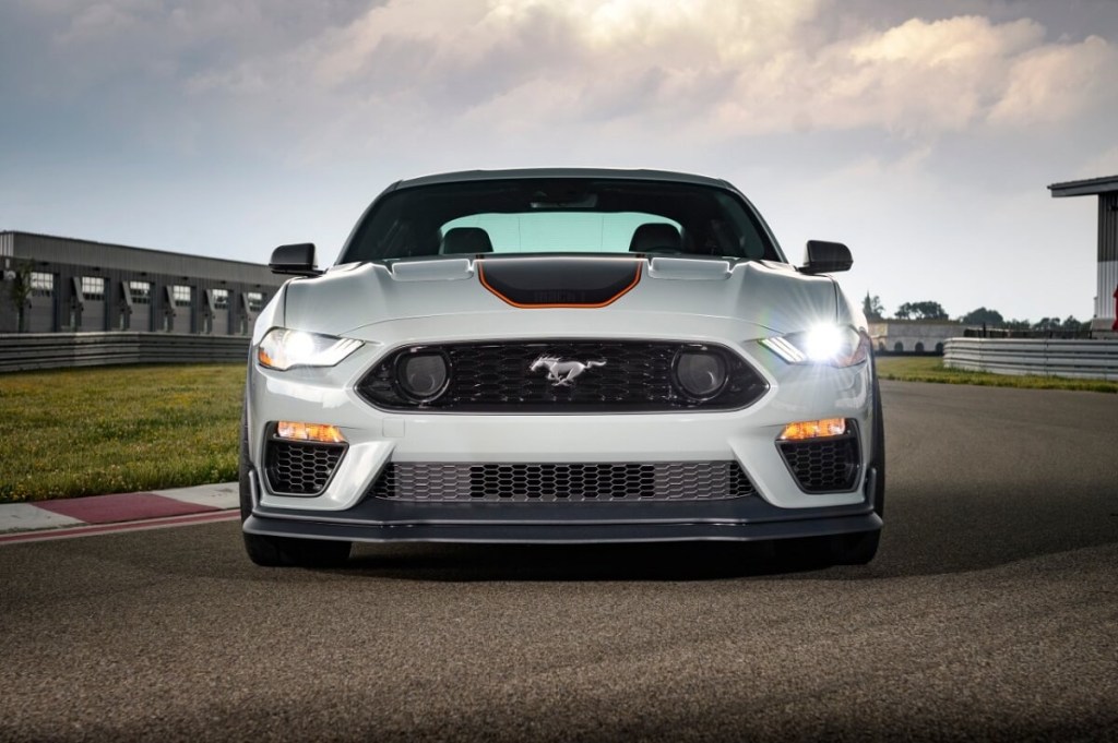 The 2023 Ford Mustang Mach 1 parks on a track with its lights on. 