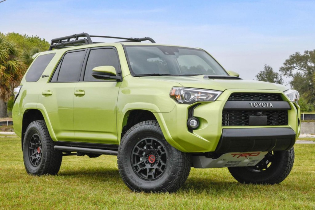 A green Toyota 4Runner TRD Pro sits on a grass field. This 4Runner has an aftermarket supercharger installed on its engine. 