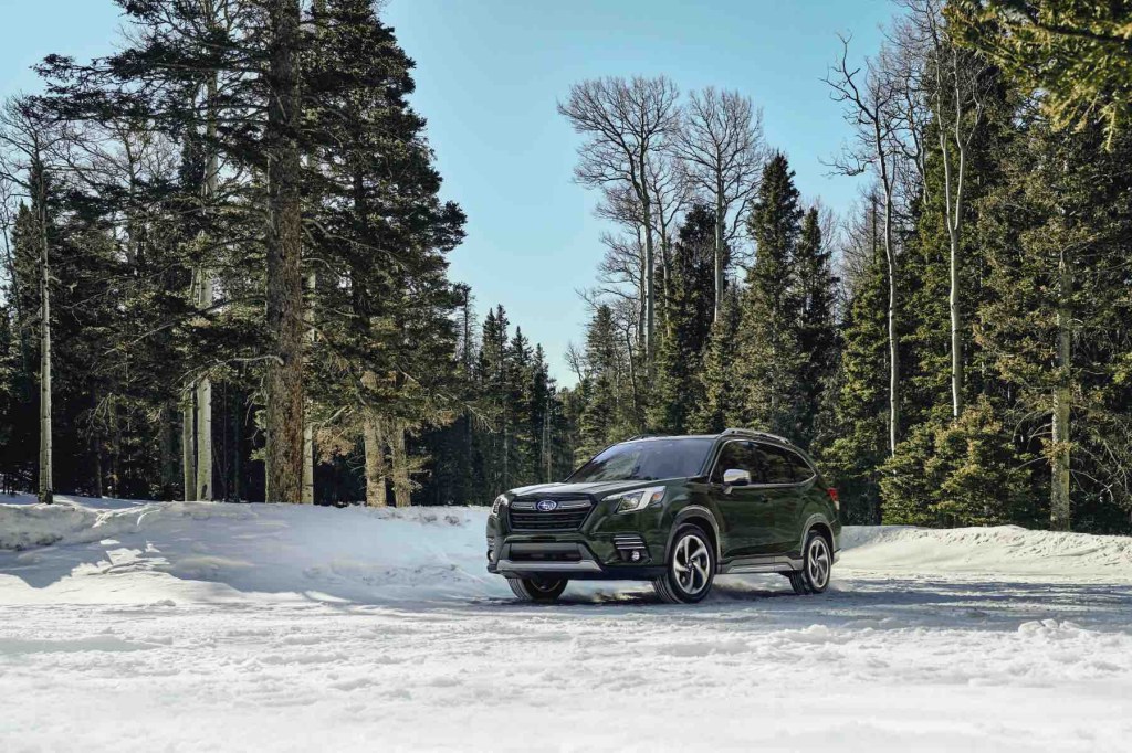 A 2023 Subaru Forester sits in a snowy forest. The Forester has one of the lowest projected cost of ownership ratings of any compact SUV.