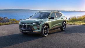 A green 2024 Chevrolet Trax sits in front of a lake.