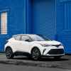 A white 2022 Toyota C-HR in front of a bright blue wall.