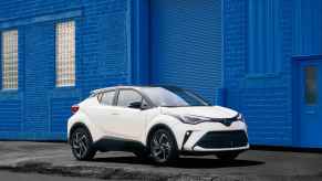 A white 2022 Toyota C-HR in front of a bright blue wall.
